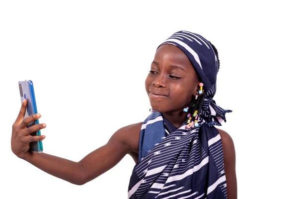 アフリカの伝統的なふんどしを着て携帯電話で写真を撮るかわいい女の子の笑顔 — ストック写真