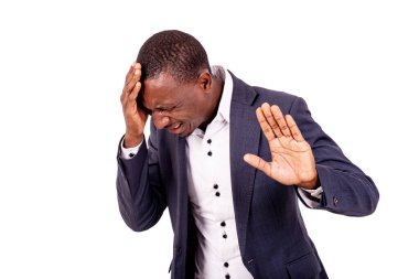 Baş ağrısı olan genç bir iş adamının portresi eliyle bir dur işareti yapıyor..