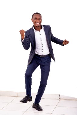 Yakışıklı genç bir işadamının portresi kameraya gülümserken kazanan bir jest yapıyor..