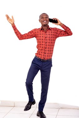 Gülümserken cep telefonuyla konuşan genç ve yakışıklı bir işadamının portresi..