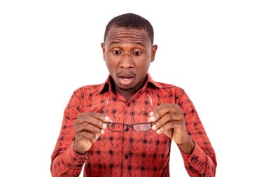 Beyaz arka planda duran kareli gömlekli yakışıklı bir adam şaşırmış gözlüklere bakıyor..