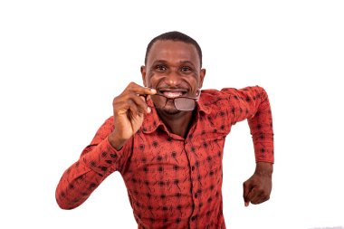 Beyaz arka planda koşan ve elinde gözlüklerle gülen kareli gömlekli yakışıklı bir adam..