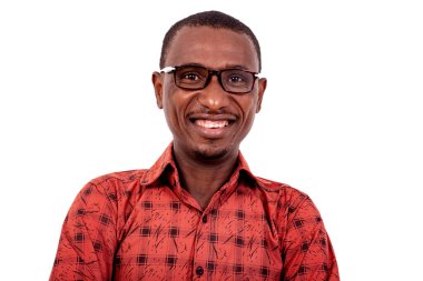 Beyaz arka planda dikilip kameraya gülümseyen, gözlüklü, kareli gömlekli yakışıklı bir adam..