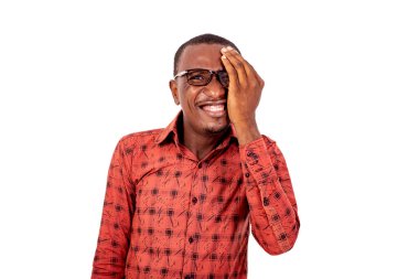 Kareli gömlekli yakışıklı bir adam beyaz arka planda duruyor. Gözlüğü bir gözü kaplıyor ve gülümsüyor..