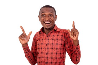 Kareli gömlekli yakışıklı bir işadamı beyaz arka planda dikiliyor zafer jestleri yapıyor ve kameraya bakıp gülüyor..