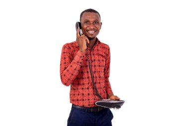 Kareli gömlekli yakışıklı bir işadamı beyaz arka planda dikilip telefonda gülümsüyor..