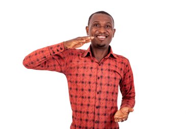 Kareli gömlekli yakışıklı bir işadamı beyaz arka planda dikiliyor. Büyük boy işareti gösteriyor, gülüyor..