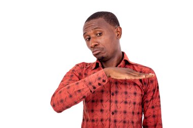 Kareli gömlekli genç bir adam beyaz arka planda dikiliyor ve surat yapıyor..