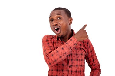 Kareli gömlekli genç adam beyaz arka planda dikiliyor. Parmağını yana kaldırıp bağırıyor..
