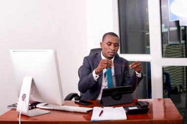 Ofiste çalışan bir iş adamının portresi. Elinde dijital tabletle gülümsüyor..