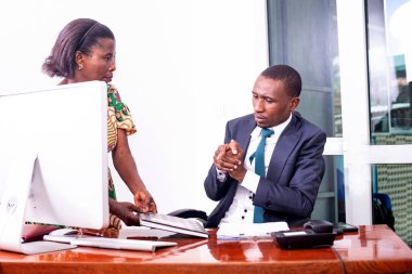 Ciddi bir genç işadamı ve sekreterinin ofiste sohbet ederken portresi..