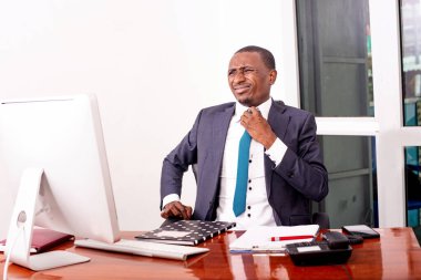 Ofisteki bilgisayarın önünde oturan işadamı kravatını gevşetiyor..