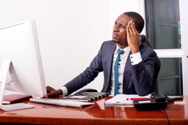 Ofiste baş ağrısı çeken genç bir iş adamının portresi..