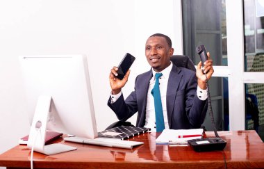 Ofiste dizüstü bilgisayarda çalışan ve gülümseyen bir iş adamının portresi..