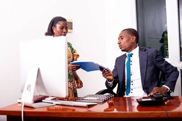 Portre sekreteri ofisteki patronuna bir belge veriyor.