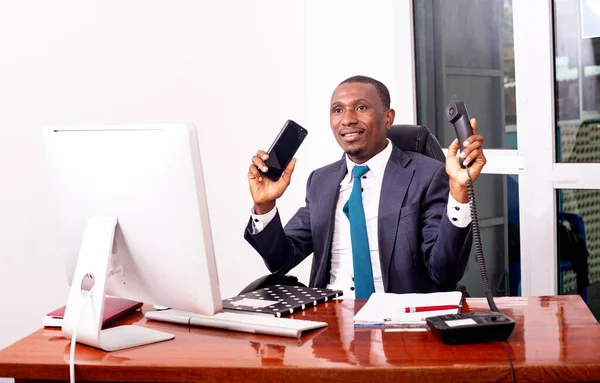 Ofiste dizüstü bilgisayarda çalışan ve gülümseyen bir iş adamının portresi..