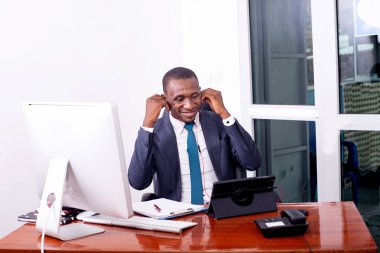 İşadamı, dijital tablet üzerinde video görüşmeleri yaparken ve belgelerde notlar alırken ofisinde çalışıyor..