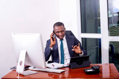 İş adamı telefonda konuşuyor ve ofiste gülümserken dijital tablet üzerinde çalışıyor.