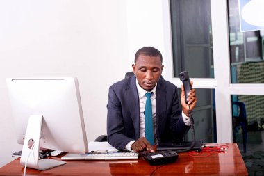 Ofisteki telefon ahizesinde ciddi bir iş adamının portresi..