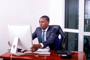 Ofiste dizüstü bilgisayarla çalışan konsantre bir iş adamının portresi..