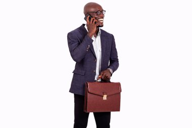 Elinde evrak çantası olan yakışıklı bir işadamının portresi ve gülümserken cep telefonuyla konuşması..