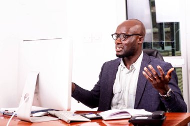 Ofiste dizüstü bilgisayarla çalışan şaşkın iş adamının portresi..