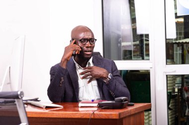 Ofiste cep telefonuyla konuşan üzgün yetişkin iş adamının portresi.