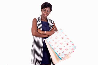 Alışveriş çantası tutan ve kollarını kavuşturan kendinden emin genç bir kadının portresi..