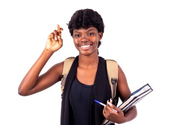 Sırt çantası taşıyan, kitap tutan ve gülümseyen genç kız..