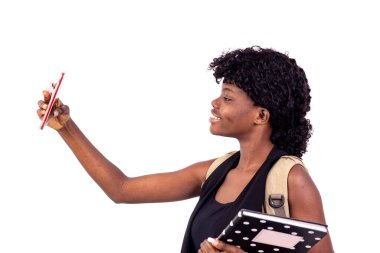 Sırt çantası takan genç kız cep telefonuyla gülümsüyor..