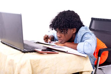 Genç öğrenci bir odada dizüstü bilgisayar kullanarak çalışıyor. .