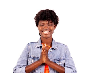 Ceketli genç bir öğrenci beyaz arka planda dua ediyor, gülümsüyor..