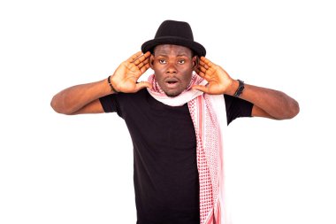 Şapka ve eşarp takan genç adam daha iyi dinlemek için iki elini de kulağına koydu..