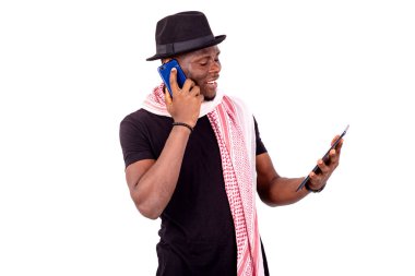 Elinde dijital tablet olan ve cep telefonuyla gülümseyen yakışıklı bir gencin portresi..