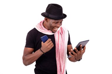 Dijital tablet taşıyan mutlu bir gencin portresi ve zafer jesti yaparak gülümsüyor..