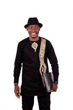 Yakışıklı, iyi giyimli, elinde dizüstü bilgisayarla gülümseyen bir gencin portresi..