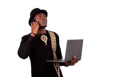 Yakışıklı, iyi giyimli, dizüstü bilgisayarı olan ve cep telefonuyla konuşan genç bir adamın portresi..