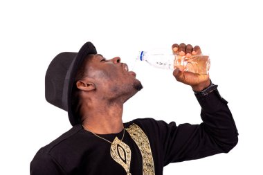 Plastik şişeden maden suyu içen iyi giyimli bir gencin portresi..