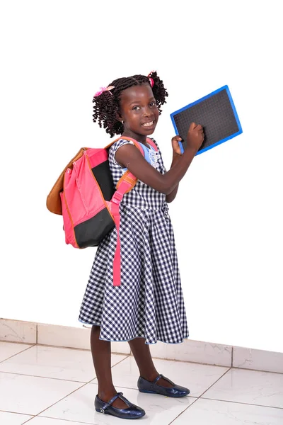 一个穿着校服 用粉笔写在写字板上 笑着的漂亮小女孩的肖像 — 图库照片