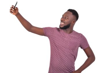 Gülümseyen cep telefonuyla fotoğraf çeken yakışıklı bir gencin portresi..