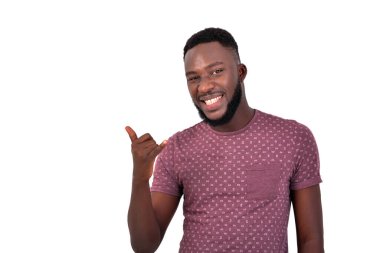 Kameraya gülümserken parmaklarıyla bir telefon hareketi yapan yakışıklı bir gencin portresi..