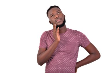 Ayakta durup düşünen yakışıklı bir gencin portresi. beyaz arkaplanda izole