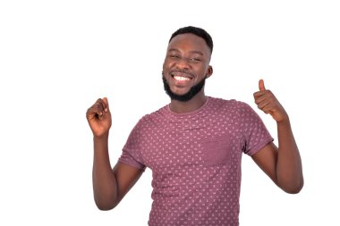 Kameraya gülümserken parmağını gösteren yakışıklı, mutlu bir gencin portresi..