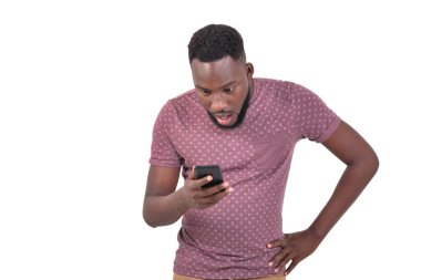 Cep telefonuna bakan yakışıklı, afallamış genç bir adamın portresi..