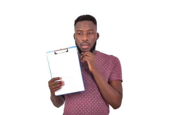 Portrait Young Man Thinks Hand Chin Holds Clipboard —  Fotos de Stock