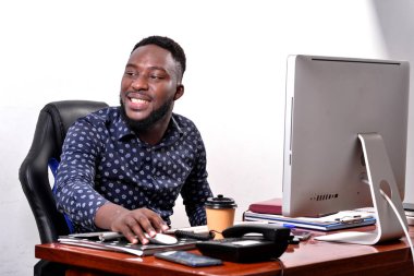 Ofiste dizüstü bilgisayarla çalışan mutlu genç bir iş adamının portresi..