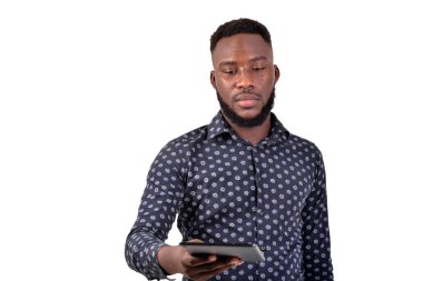 Tabletle beyaz arka planda duran sakallı genç bir adam..