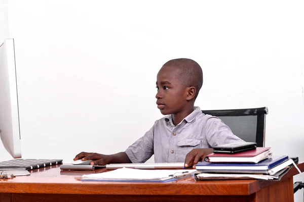 Ένα Νεαρό Αγόρι Που Κάθεται Ένα Γραφείο Κοιτάζοντας Μια Οθόνη — Φωτογραφία Αρχείου