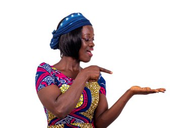 Geleneksel peştemalli güzel bir genç kadının portresi ve avucundaki boş boşluğu işaret ederken gülümsüyor..