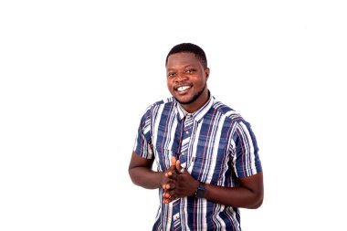 Tatmin olmuş genç bir adamın portresi. Kameraya gülümserken ellerini bir arada tutuyor..